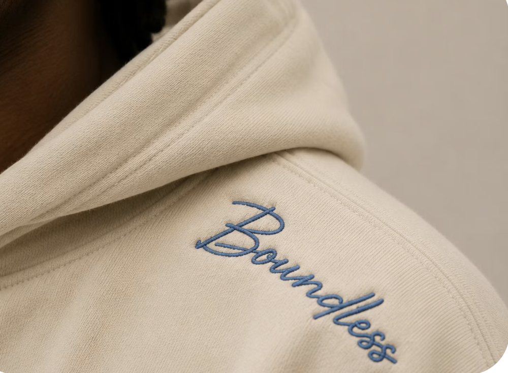 Cream hoodie with Boundless embroidered in blue script